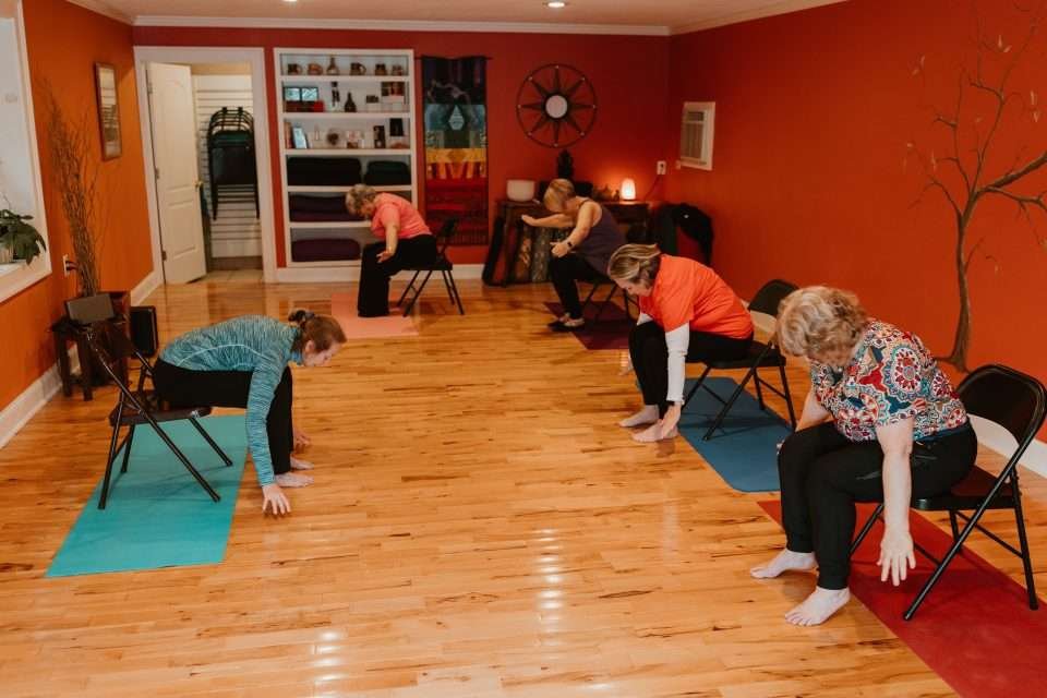 Bonnie and class performing a seated forward fold